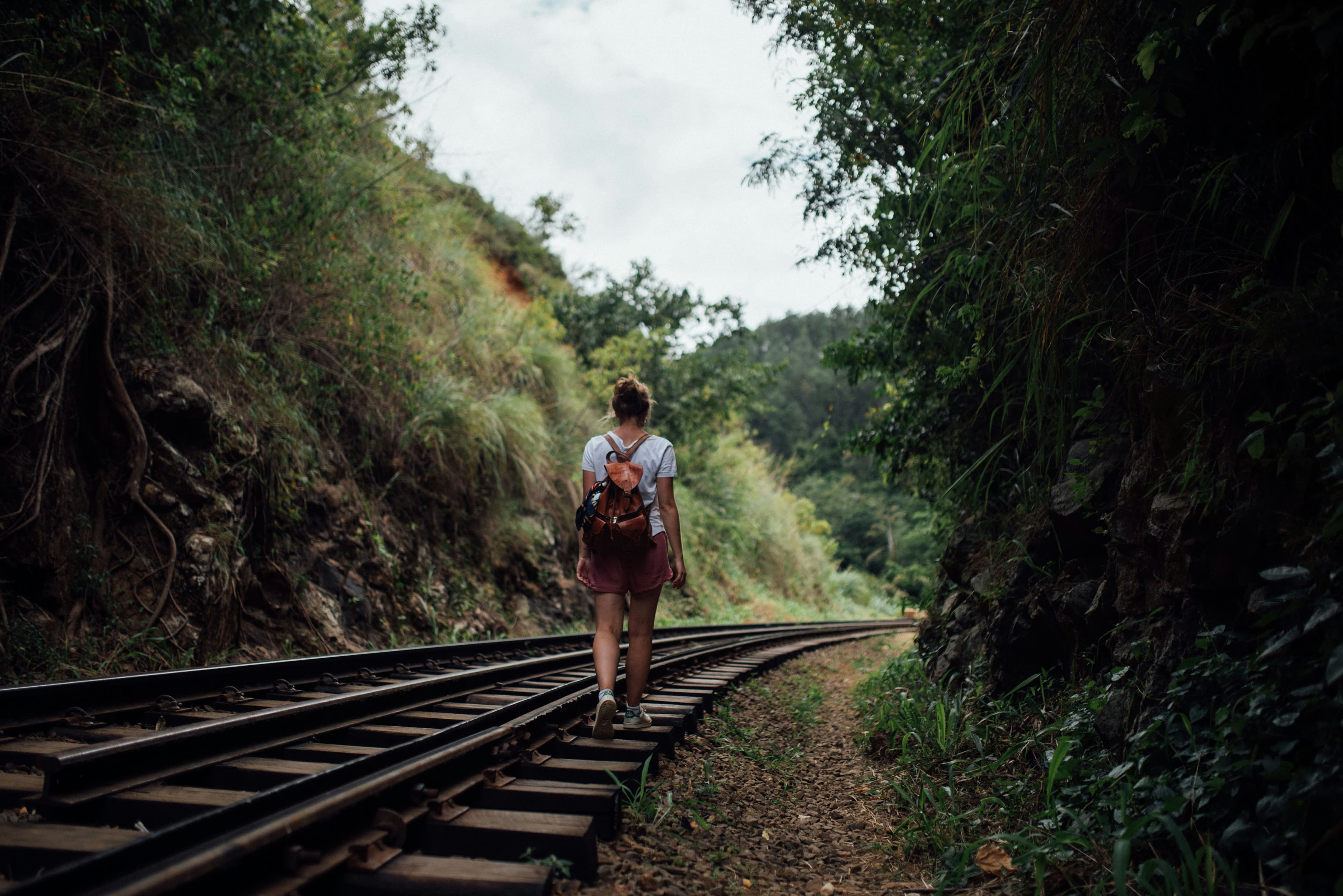 Un viaggiatore cammina lungo una ferrovia nelle colline dello Sri Lanka